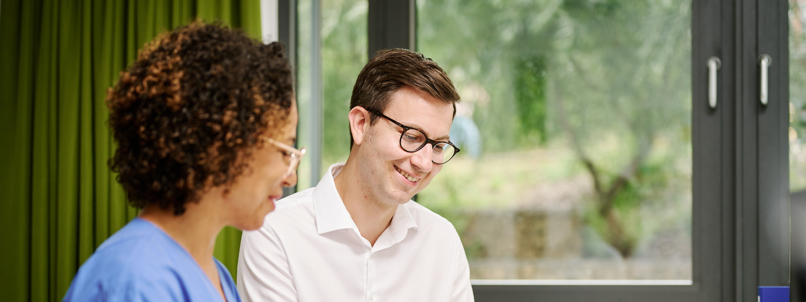 Tim Schürkamp am Schreibtisch mit Praxisanleiterin