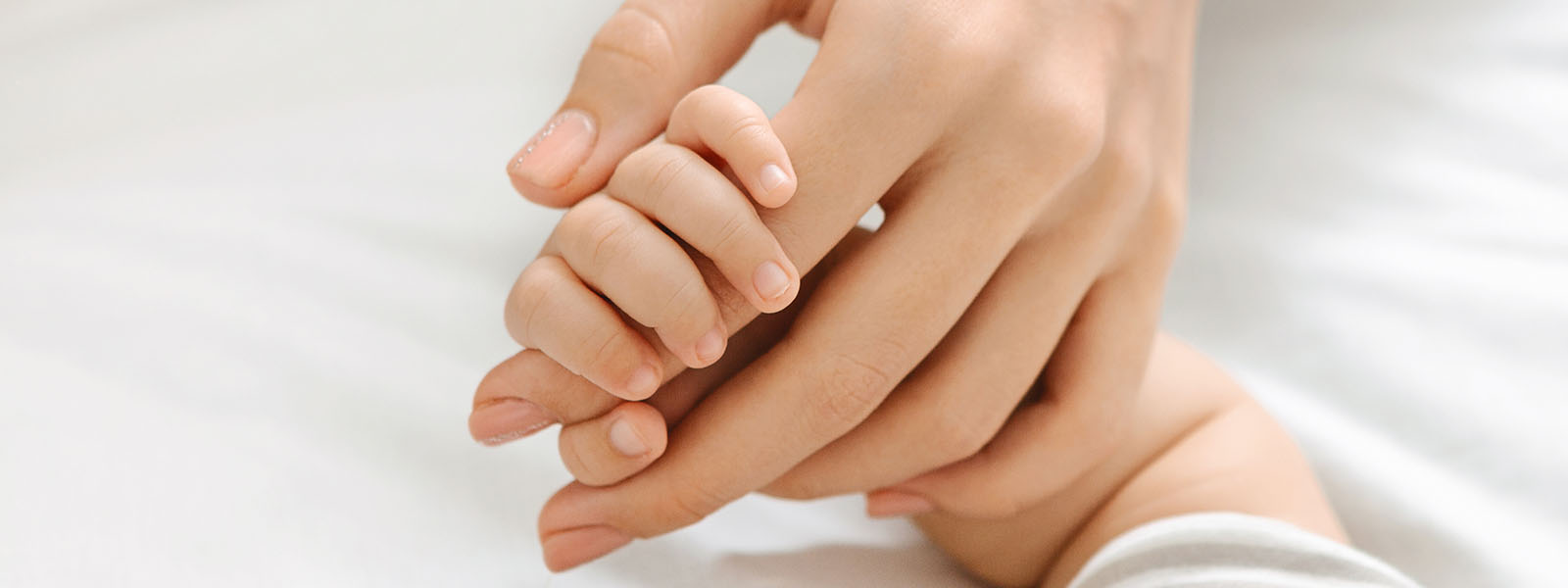 Kinderhand hält Zeigefinger des Erwachsenen liebevoll fest