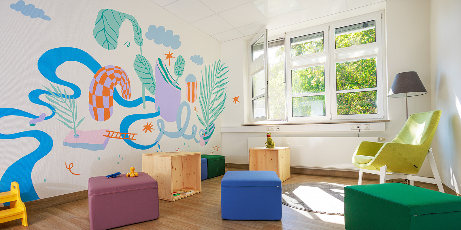 Aufenthaltsbereich des Amalie Nathan Haus mit bunter Grafik an der Wand