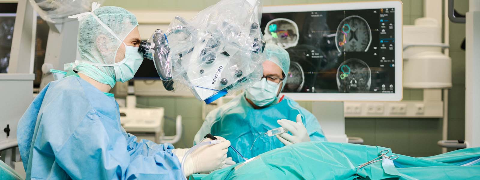 Prof. Dr. Brandner schaut bei OP durch das Mikroskop