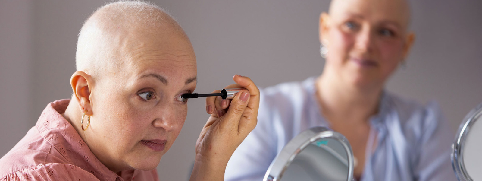 Zwei Frauen schminken sich beim Kosmetikseminar