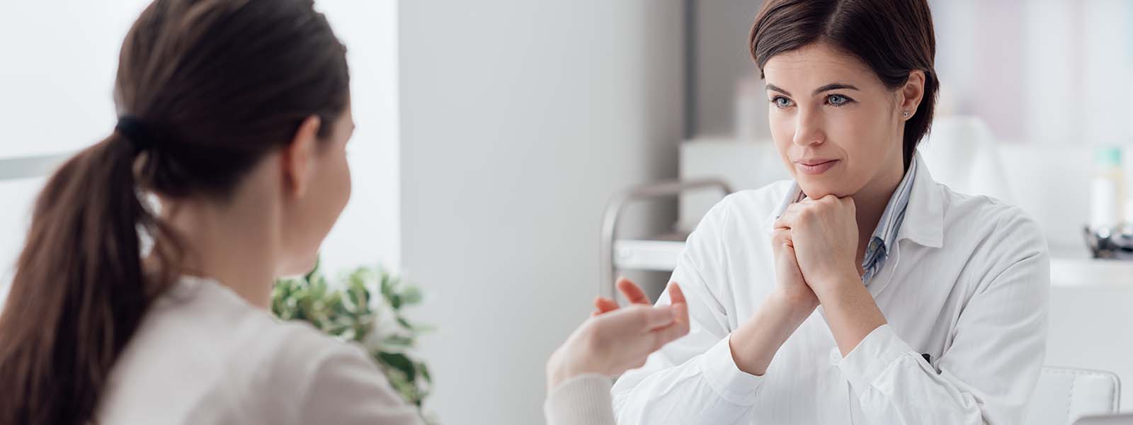 Ärztin hört der vor ihr sitzenden Patientin aufmerksam zu
