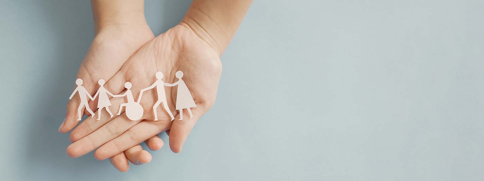 Zwei Hände halten Papiergierlande mit diversen Figuren